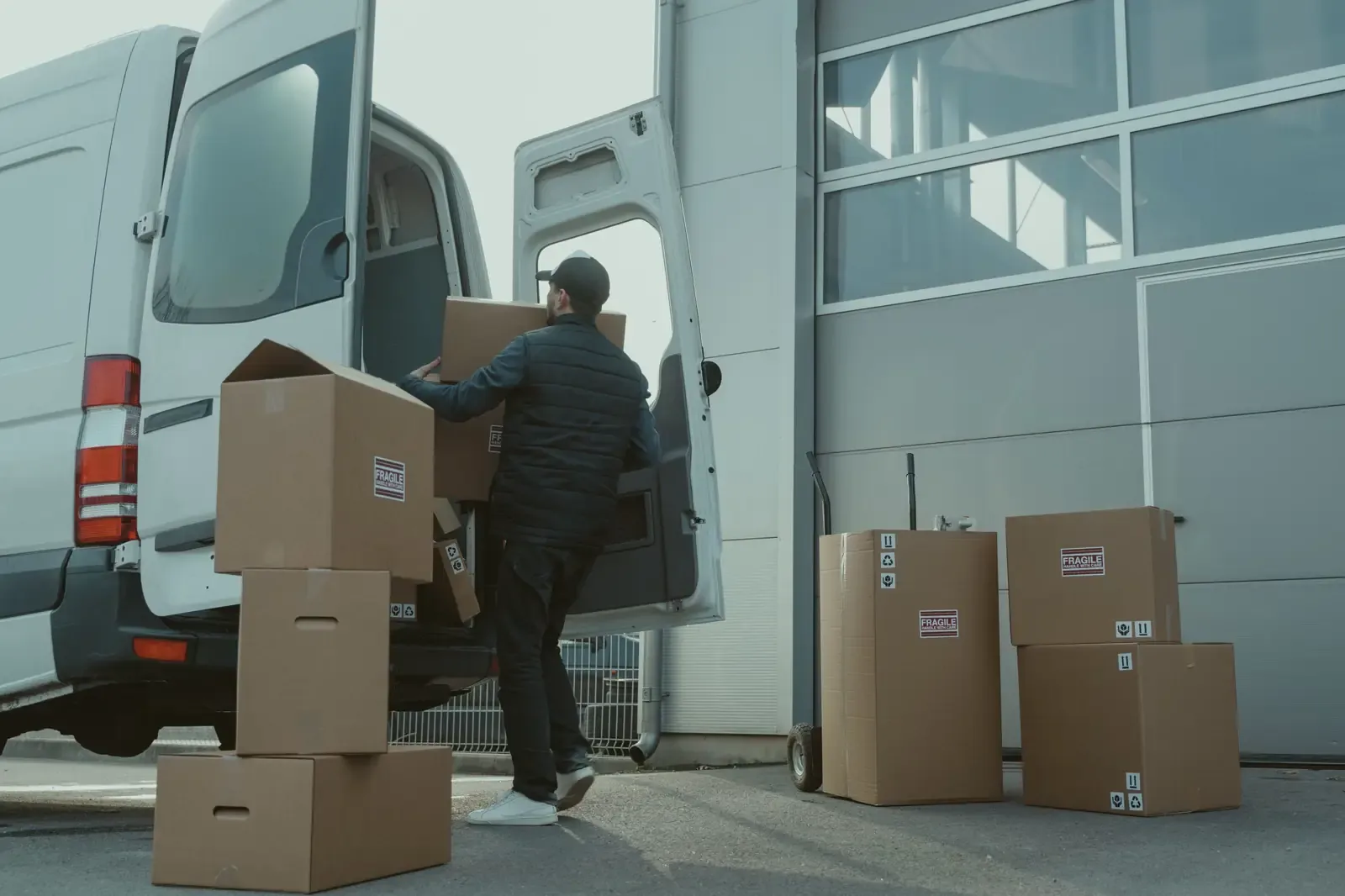 Een bezorger laadt dozen uit een bestelbus