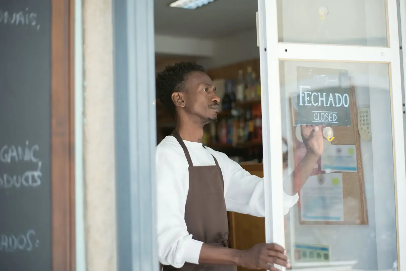 Een winkelmedewerker zet ’s ochtends de deur van de zaak open