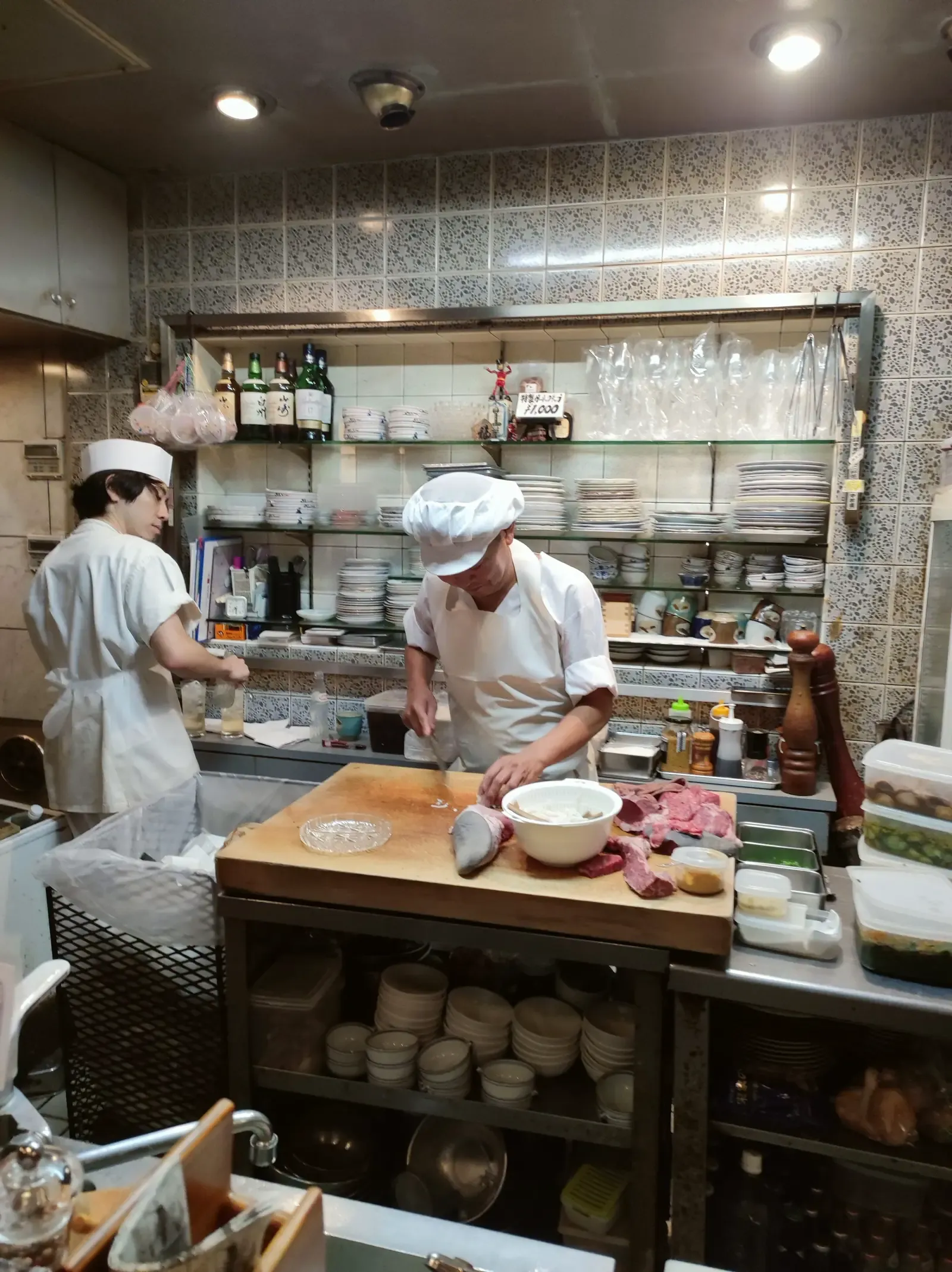 Twee koks aan het werk in een kleine restaurantkeuken